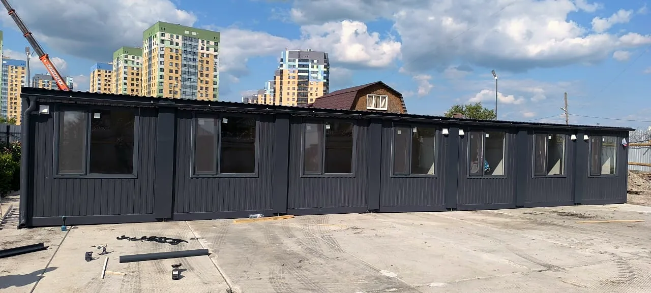 Модульное здание с тёмным фасадом и панорамными окнами